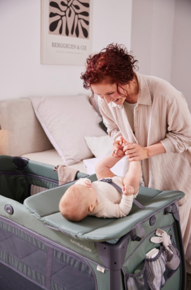 Mother changing her baby on the Hauck Play N Relax Center changing table