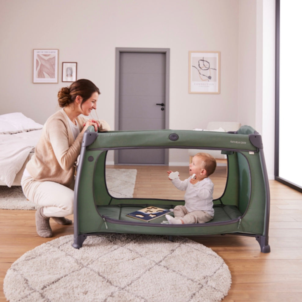 Baby playing inside the Hauck Play N Relax Center playpen with mum watching
